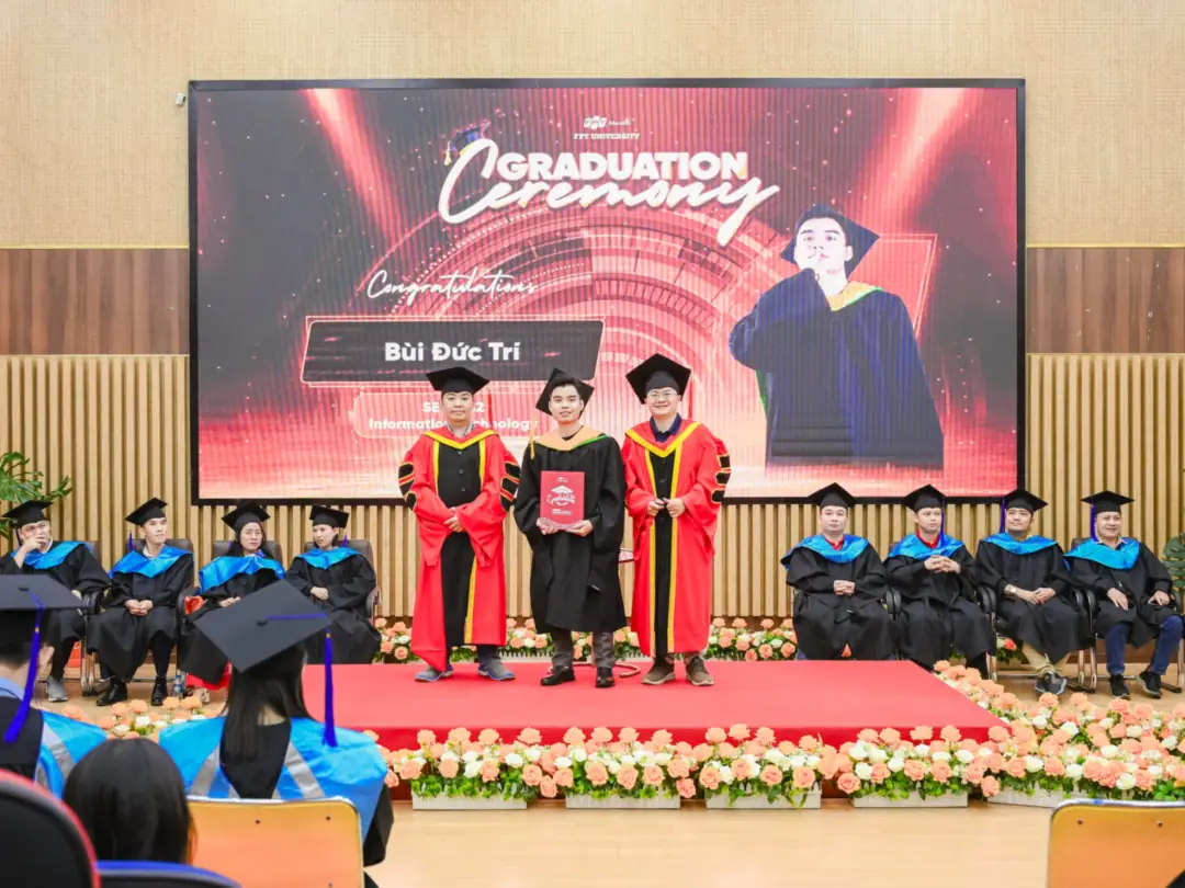 Bui Duc Tri on stage at the FPT University graduation ceremony, his name displayed on the big screen