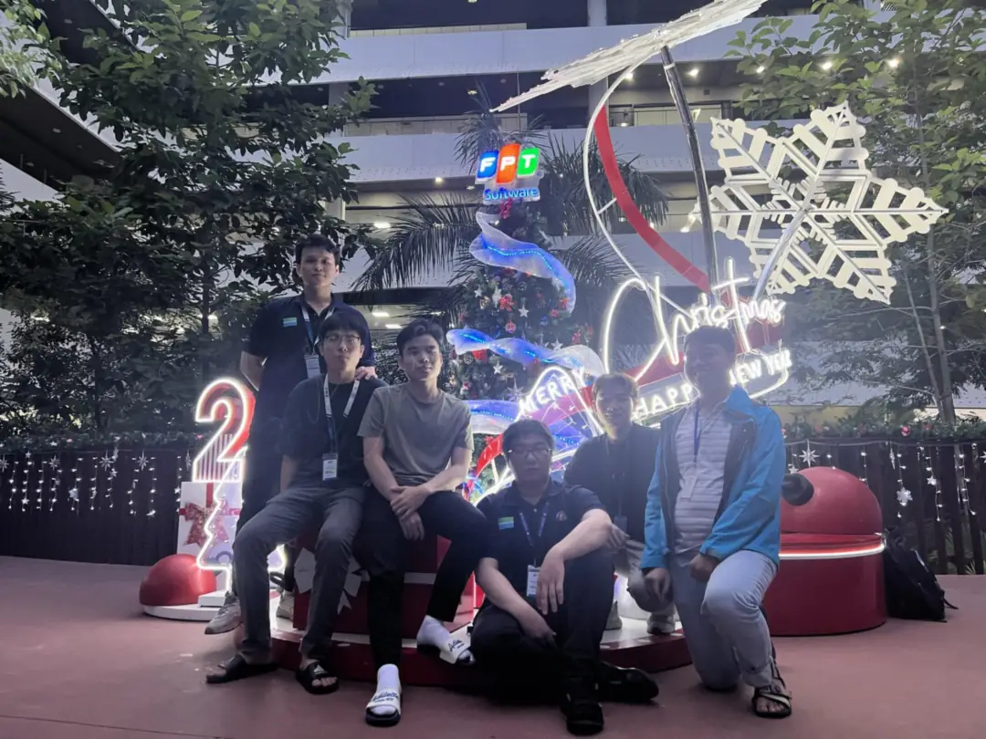Colleagues posing in front of a Christmas display at the FPT Software campus