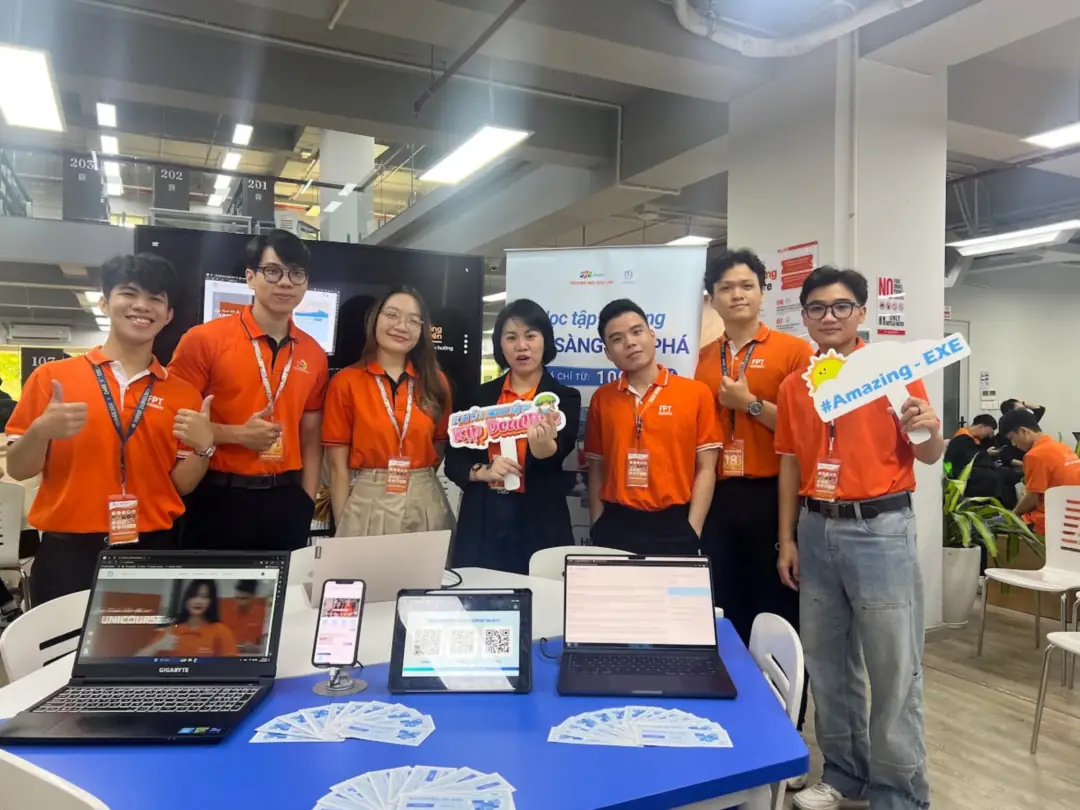 The Unicourse team at their product demo booth, wearing orange FPT shirts